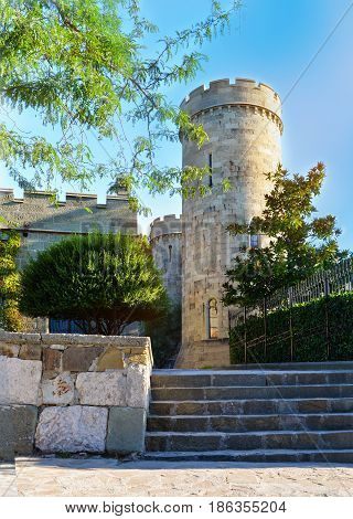 Vintage old-fashioned castle with turret, sunny morning. Vorontsov palace, Alupka, Crimea. Blue sky, mountain landscape. Scottish Baronial, Mughal architecture, Gothic Revival architecture styles.