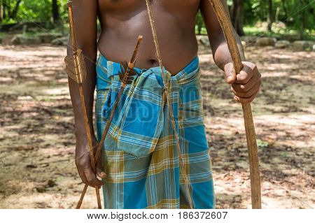 Closeup of Vedda man standing in waistcloth holding arrow