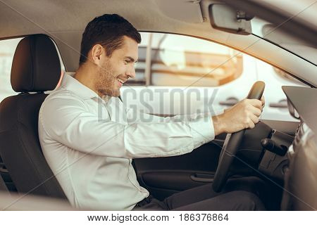 Young man sitting in a car test drive rental service