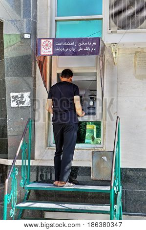 Bandar Abbas Hormozgan Province Iran - 16 april 2017: An Iranian man gets cash in an external ATM.
