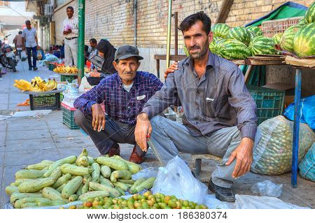 Bandar Abbas Hormozgan Province Iran - 16 april 2017: Two Iranian fruit traders are sitting on the sidewalk near their product.