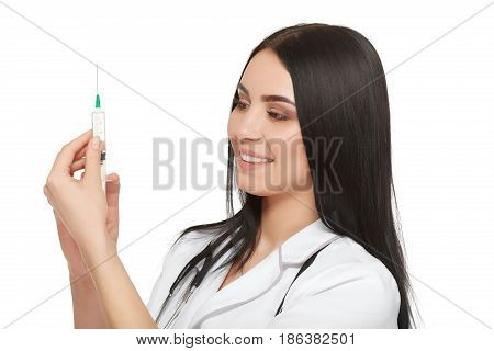 A portrait of a young female doctor smiling with a syringe in her hand. Portrait of a beautiful woman doctor. Isolated over white background. Young woman doctor holding syringe on white background