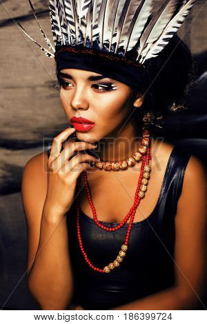 young pretty woman with make up like red indian, futher in hair, fashion hallowen concept creative