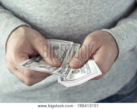Hands counting dollars. Selective focus. Shallow DOF