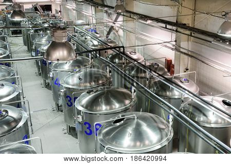 Brilliant metal cisterns lined up in long rows. Modern food production.