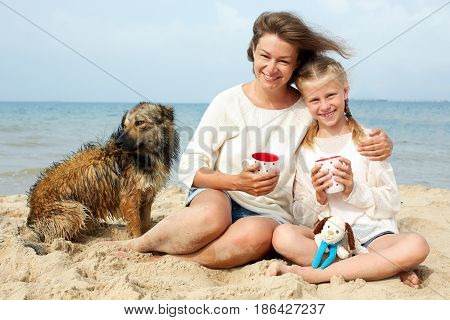 Happy family with dog on the beach