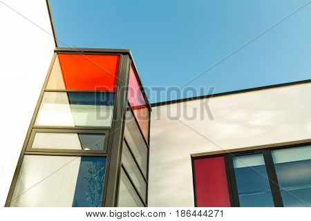 Red and white rendered modern building facade on a bright sunny day with clear sky. Abstract background. Space for text