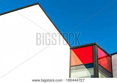 Red and white rendered modern building facade on a bright sunny day with clear sky. Abstract background. Space for text