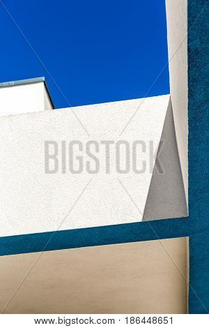Architectural Corner detail of modern white and blue rendered building with blue sky