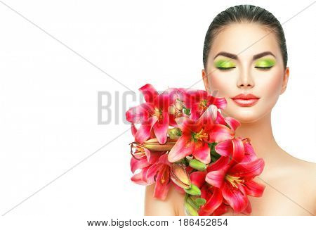 Beauty Girl with Lilly Flowers bouquet. Beautiful Spa Model woman with Blooming pink lily summer flowers. Skin care. Nature. Holiday Creative Makeup. Fashion Make up. Isolated on white Female Portrait