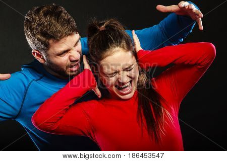 Husband abusing wife. Aggresive man screaming at crying scared woman. Domestic violence aggression. Bad relationship.