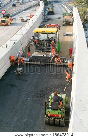 Workers And Vehicles During The Asphalting Of The Highway