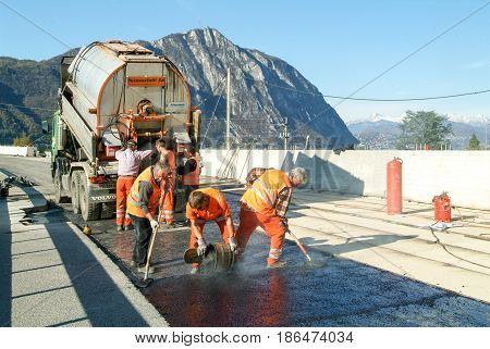 Workers And Vehicles During The Asphalting Of The Highway