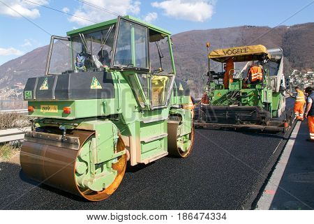 Workers And Vehicles During The Asphalting Of The Highway