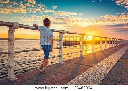 Boy watching sunset from St. Kilda Jetty Melbourne Victoria Australia. Color toning effect