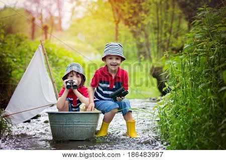 Cute Children, Boys, Playing With Boat And Ducks On A Little Rive