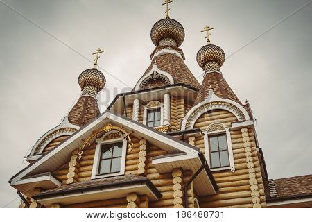 Modern wooden orthodox church in Voronezh, Russia, Domes with crosses at background of dark dramatic sky