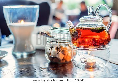 Close-up of modern glass teapot with tea inside in cafe