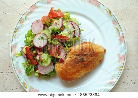 Baked Chicken Breast With Vegetable Salad On A White Plate