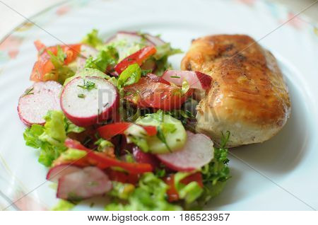Baked Chicken Breast With Vegetable Salad On A White Plate