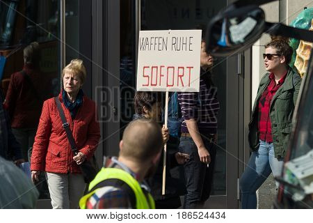BERLIN - MAY 01 2016: Poster Ceasefire immediately. Members of trade unions workers and employees at the demonstration on the occasion of Labour day.