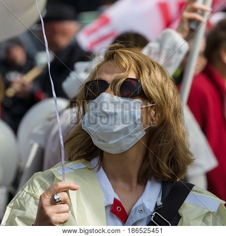 BERLIN - MAY 01 2016: Woman in a medical mask. Members of trade unions workers and employees at the demonstration on the occasion of Labour day.