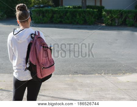 Teenage Girl with Cellphone and Backpack going to school