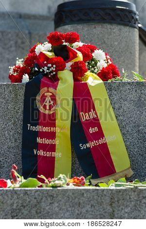 BERLIN - MAY 08 2016: Victory in Europe Day. A wreath in the colors of the German flag at the foot of the monument to Soldier - liberator in the Soviet War Memorial in Treptower Park. The inscription in German: Thanks to Soviet soldiers.