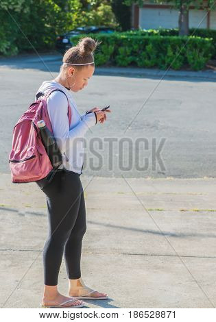 Teenage Girl with Backpack and Cellphone going to School