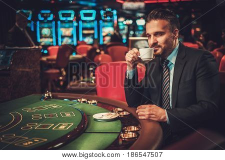 Upper class man behind gambling table in a casino
