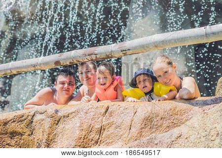 Happy adults and children in a water park.