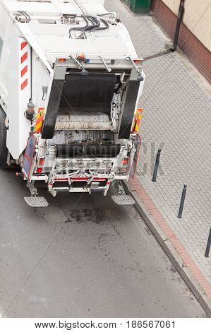 Modern white garbage dustcart truck on city street. Recycling in town concept.