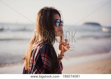 young stylish happy hipster woman traveling around the world wearing aviator sunglasses, denim shirt, tropical island lagoon vacation.