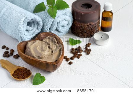 Spa setting with cosmetic clay mask for body, Towel  Essential oil and coffee beans