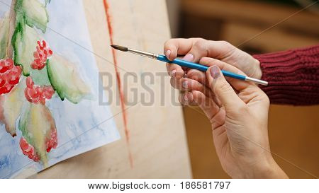 Girl paints still life in watercolor art school. The teacher helps to correct the miscalculations in the picture. Hands close-up. Courses of drawing for adults.