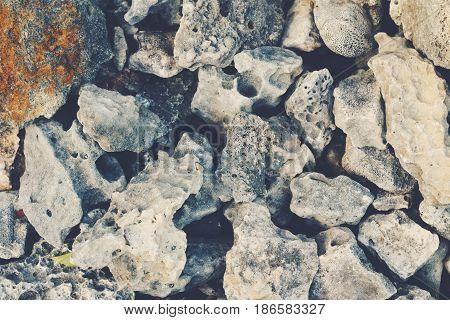 Huge large textured sea ocean stones and pebbles on the ground background wallpaper closeup toned with retro vintage film effect style filters