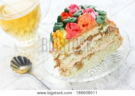 Piece of beautiful layered birthday cake with cream flowers