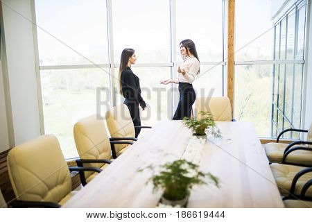 Two Businesswomen Having Informal Meeting In Modern Office