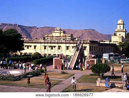 JAIPUR, INDIA - NOVEMBER 24, 1993 - Elevated view of people looking at the giant sundial known as the Samrat Yantra at Jantar Mantar Jai Singhs Observatory with the City Palace also known as the Chandra Mahal to the rear Jaipur Rajasthan India, November 2
