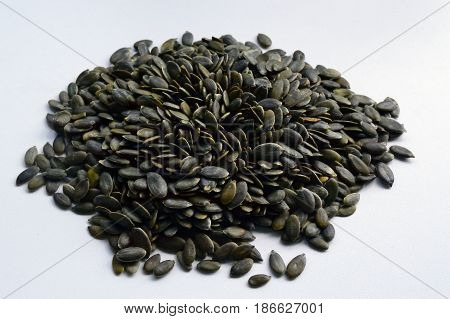Peeled pumpkin seeds on white background .