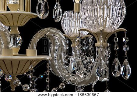 Contemporary glass crystal chandelier isolated on black background. close-up chandelier.