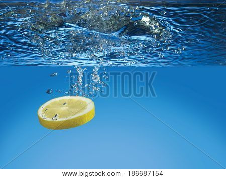 Slice of a Lemon falling in water