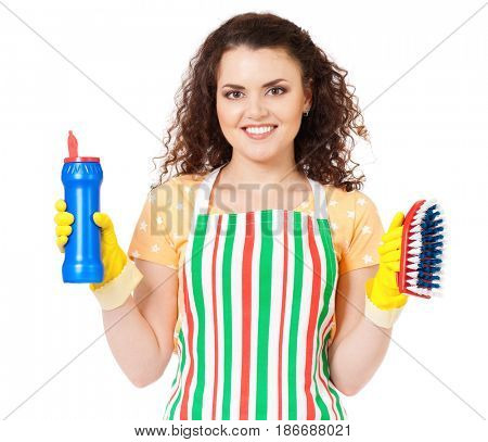 Smiling young woman holding bottle of chemistry for cleaning house. Cleaning concept. Beautiful happy girl with cleaning tools and products on white background. Housekeeper isolated portrait.