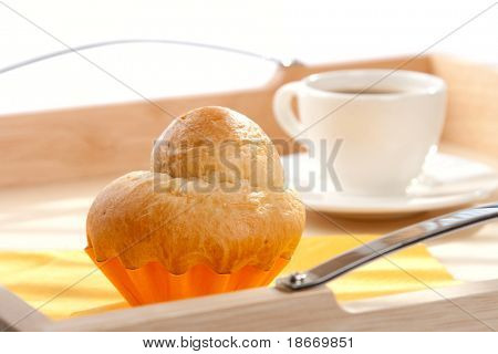 ฝรั่งเศส Brioche และถ้วยกาแฟสีขาวบนพื้นหลัง กรมตื้น