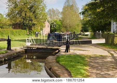 A narrowboat being raised in locks on the Shropshire Union canal in England UK