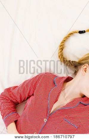 Woman Lying On Bed Wearing Pink Pajamas