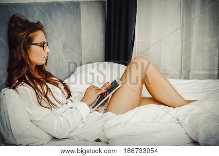 Woman doing some late night browsing on her tablet computer.