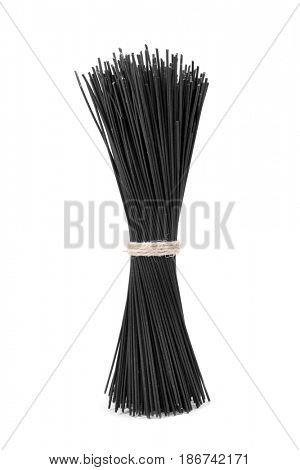 a pile of uncooked black spaghetti on a white background