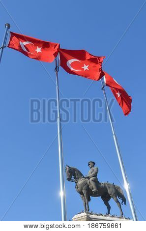 The statue of Ataturk and national flags of modern Turkey in Ulus - Ankara, Turkey