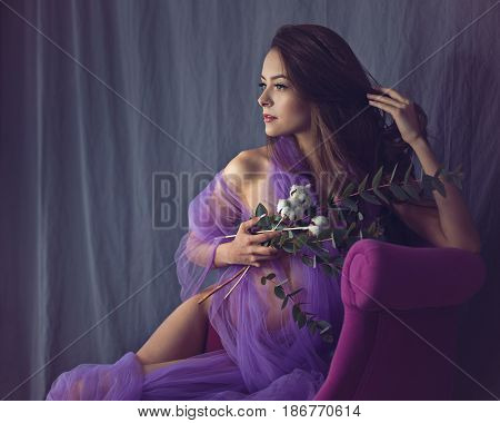 Lovely girl in underwear. Sensual photo. She's wearing a bikini and a silk kerchief. The girl is holding flowers and straightening her hair.
